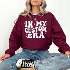 "In My Era Custom Sweatshirt, Personalized Sweatshirt, Custom Era Hoodie, Concert Outfit, In My Era Sweater HOW TO ORDER 1. Check our photos for color and sizing options.  2. Choose your quantity. 3. Select your size and color from the drop-down menus. 4. Click \"ADD TO CART\" to add the shirt to your virtual cart.  5. Click \"PROCEED TO CHECKOUT\" to purchase your shirt.  6. Your shirt is now off to production! We will process your order and your shirt will be ready to ship in 1-3 days! PRODUCT Winter Hoodie Sweatshirt With Lettering, Customizable Cotton Sweater For Fall, Customizable Crew Neck Hoodie For Fall, Customizable Cotton Sweater For Winter, Customizable Hoodie Sweatshirt For Fall, Customizable Winter Hoodie Tops, Customizable Cotton Tops For Winter, Customizable Cotton Hoodie Tops, Customizable Cotton Fall Sweater