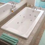 a large white bath tub sitting on top of a bathroom counter