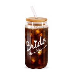 a jar filled with brown liquid next to a wooden lid and plastic straw in it