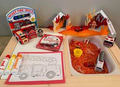 a fire truck themed birthday party with toys and paper cutouts on the table top