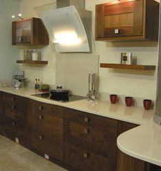 a kitchen with wooden cabinets and white counter tops, including a range hood over the stove