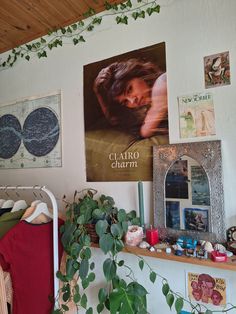 a bedroom with posters and plants on the wall