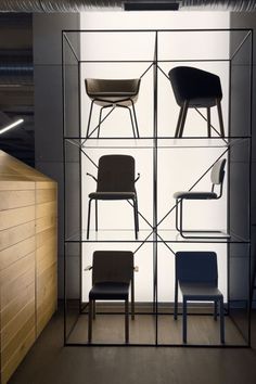 several chairs are arranged in a glass display case