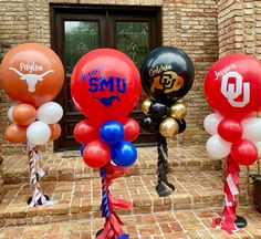 some balloons that are in the shape of basketballs and letters on them, sitting outside a brick building