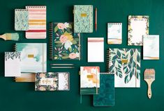 various stationery items are arranged on a green wall