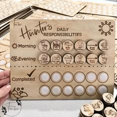 a person is holding up a wooden board with buttons on it and some other items around the board