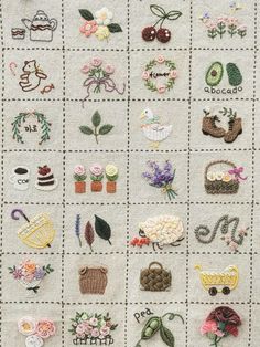 a close up of a cross stitch pattern with flowers and other items on the fabric