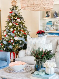 a living room with a christmas tree in the corner and decorations on the coffee table