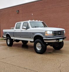 a silver pick up truck parked in front of a brick building