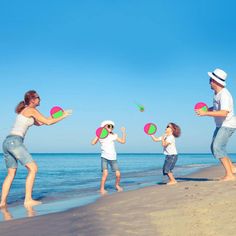 a family playing with frisbees on the beach