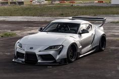 a white sports car parked in a parking lot