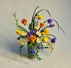 a vase filled with lots of different colored flowers