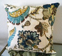 a close up of a decorative pillow on a chair with white wall in the background