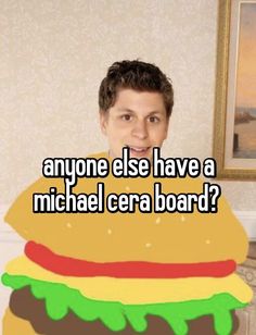 a man standing in front of a giant hamburger with the caption anyone else have a michael cera board?