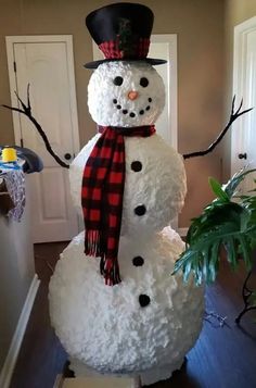 a snowman with a top hat and scarf standing in the middle of a room