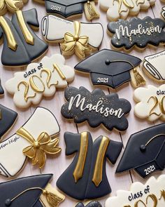 graduation cookies decorated with royal blue, white and gold icing are arranged on a table