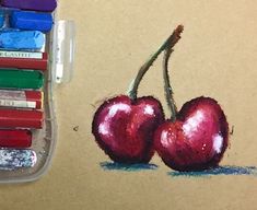 a drawing of two cherries with crayons next to it