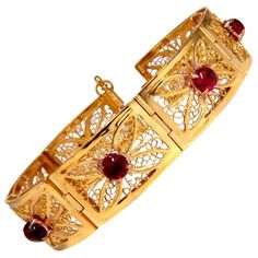 7.40ct. Natural Cabochon Spinels bracelet. Vintage Open Gilt Design Vivid Red colors. Transparent & Clean Clarity. Average 5.7mm No Enhancements & Fully Natural. 14kt. Yellow gold 37 Grams. 5.5mm wide bracelet 7.25 inches long (wearable length) 17mm wide links. Ancient Style - Pull Bar Locking $9,500 Appraisal Certificate will accompany. Elegant Cabochon Bracelets For Anniversary, Luxury Filigree Round Bracelets, Classic Cabochon Bracelets As Gift, Classic Cabochon Bracelets For Gifts, Elegant Red Bangle Gold Bracelet, Elegant Red Gold Bangle Bracelet, Luxury Red Gold Bracelet For Formal Occasions, Luxury Red Gold Bracelet For Formal Events, Yellow Gold Cabochon Bracelets For Weddings