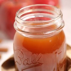 an apple cider in a glass jar on a table