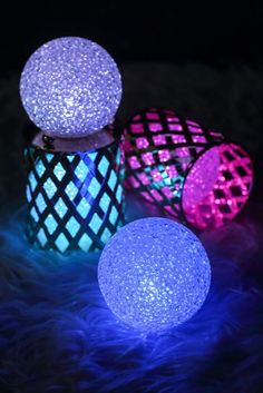 three different colored lights sitting on top of a fur covered floor next to each other