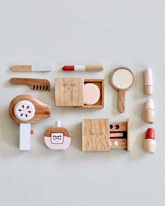 an assortment of wooden toys on a white surface with scissors, toothbrushes and other items