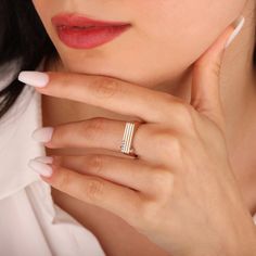 a close up of a person wearing a ring and holding her hand near her face