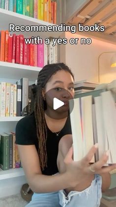 a woman sitting in front of a book shelf