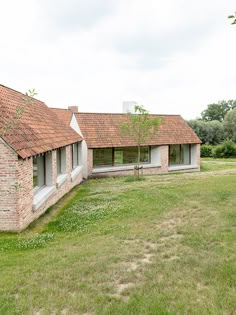 an old brick house sits in the middle of a field