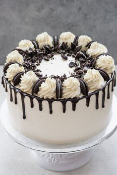 a cake with white frosting and chocolate drizzles on it's top