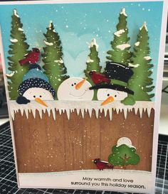 a card with snowmen and trees on it