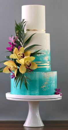 a blue and white cake with flowers on top