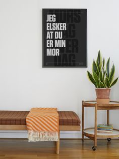 a living room with a bench, table and potted plant