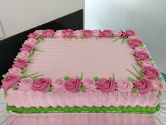 a pink and green cake sitting on top of a glass table next to a mirror