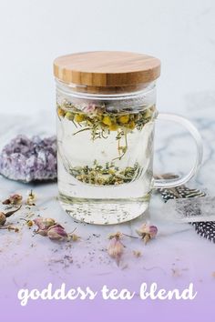 a glass jar filled with flowers and herbs