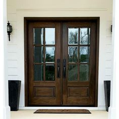 the front door is brown and has two sidelights on each side with glass panes