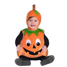 a child in a pumpkin costume sitting on the ground