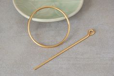 Gold hair stick, Hair bun holder, Hair jewelry A modern take on a classic shape.  A simple two-part pin that makes the most of a messy French everyday bun. This pin is our large size and is perfect for curly, lightly wavy or straight hair. ⊹ D e t a i l s 24k gold plated Matt finish Circle - 5 cm || 1.96 inch Stem - 11 cm || 4.3 inch All jewelry arrive in gift boxes. Find ideas and step-by-step tutorials on u tube. Back to shop: https://www.etsy.com/il-en/shop/closeupjewelry Thanks for stopping Hair Holder, Bun Holder, U Tube, Pin Hair, Unique Hair, Hair Stick, Hair Bun, Unique Hairstyles, Gold Hair