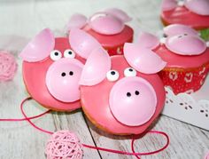 some pink cupcakes with pigs on them