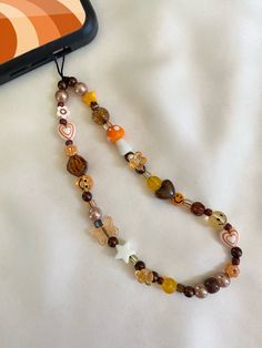 a long beaded necklace with various colored beads and charms hanging from it's end