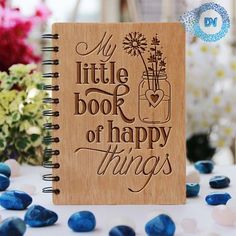 a wooden notebook with the words, my little book of happy things on it