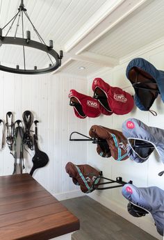 several pairs of shoes are hanging on the wall next to a wooden table and bench