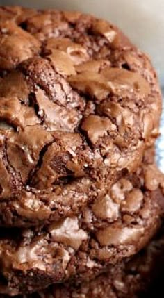 three chocolate cookies stacked on top of each other in a white and blue dish towel