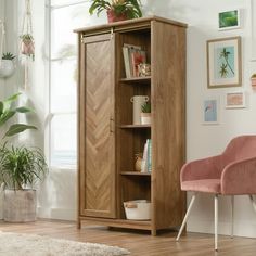 a living room with a chair, bookcase and potted plants