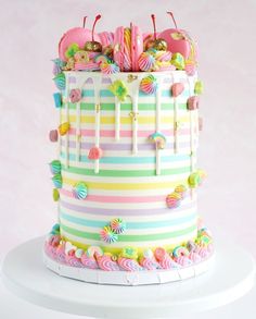 a multi - colored striped cake with candy toppings and candies on the top