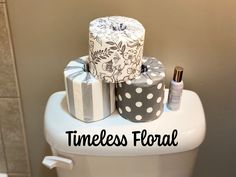 three rolls of toilet paper sitting on top of a toilet