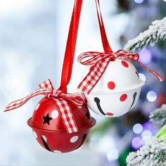 two ornaments hanging from a christmas tree decorated with red, white and black polka dots