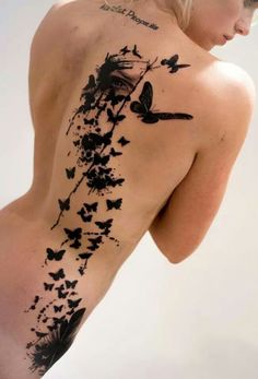 the back of a woman's body with tattoos on her chest and butterflies all over it