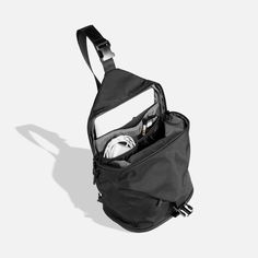 an open black bag on a white background with the contents in it's pocket