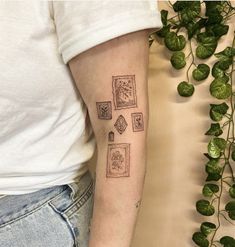 a woman's arm with tattoos on it and some plants behind the armband