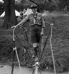 an old black and white photo of a man standing on skis in the mud